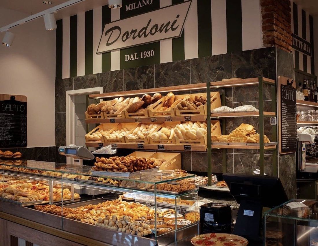 Il banco di Dordoni con la vetrina dei dolci e gli scaffali di pane sotto l’insegna Dordoni dal 1930